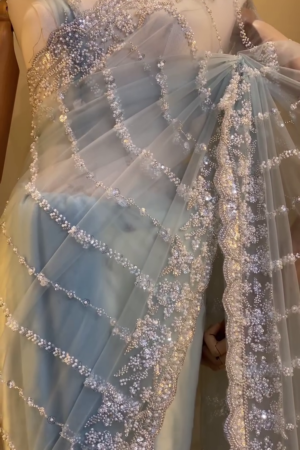 Graceful Ice Blue Designer Net Saree with All-Over Sequin, Pearl, and Bead Embroidery in Curved Stripe Pattern, Featuring Heavily Embellished Border and Matching Blouse – Ideal for Engagements, Cocktail Parties, and Modern Wedding Celebrations