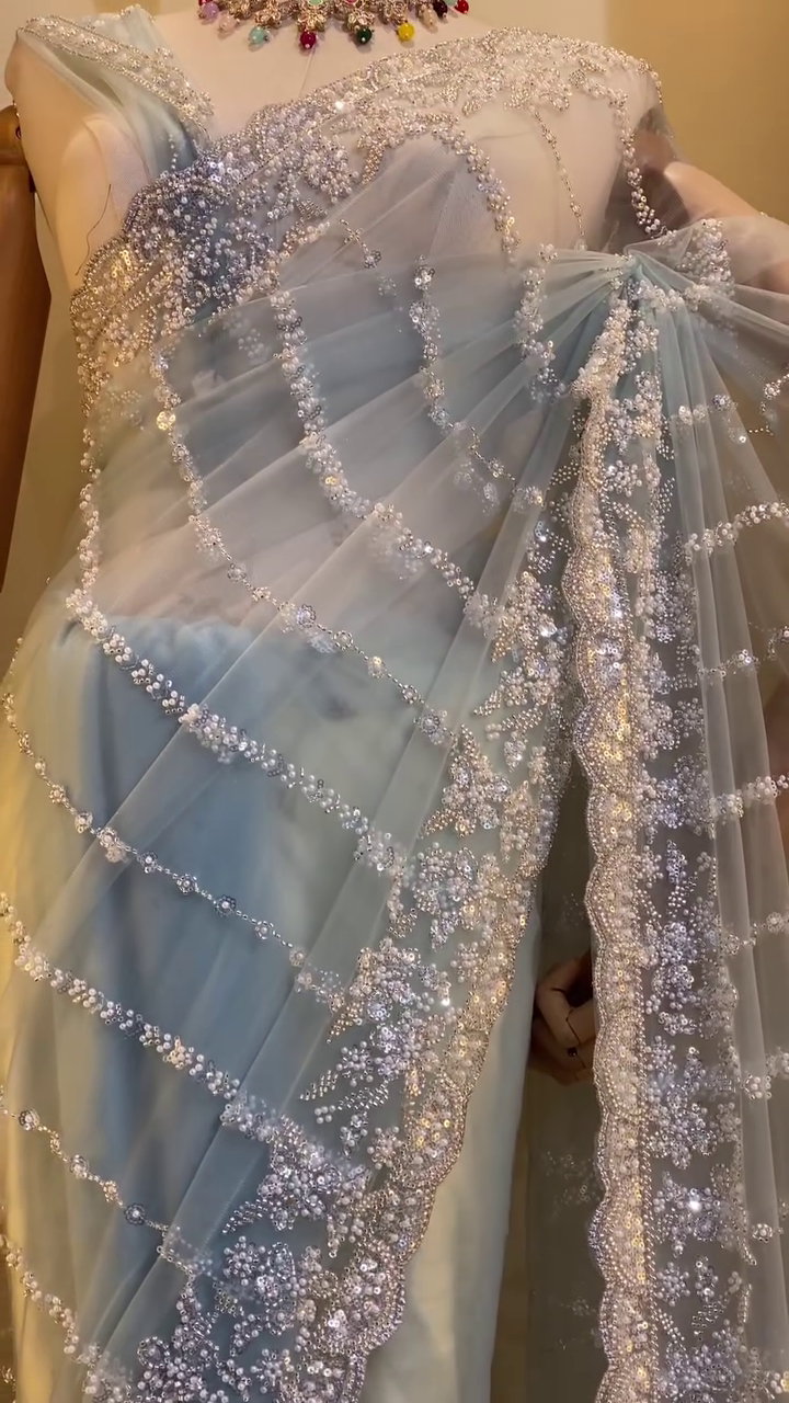 Graceful Ice Blue Designer Net Saree with All-Over Sequin, Pearl, and Bead Embroidery in Curved Stripe Pattern, Featuring Heavily Embellished Border and Matching Blouse – Ideal for Engagements, Cocktail Parties, and Modern Wedding Celebrations